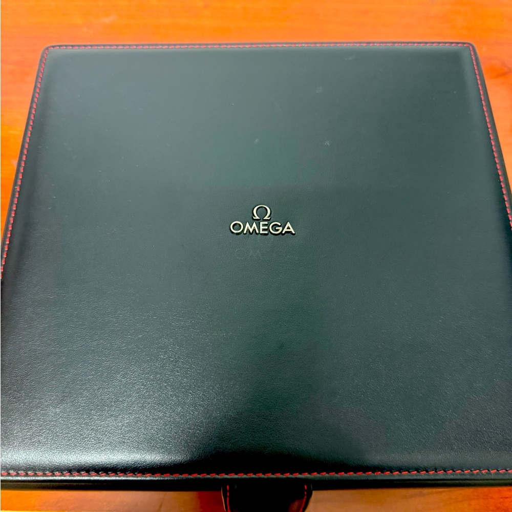 Gently used Omega brand watch storage box. Black, red stitching. Calf leather.